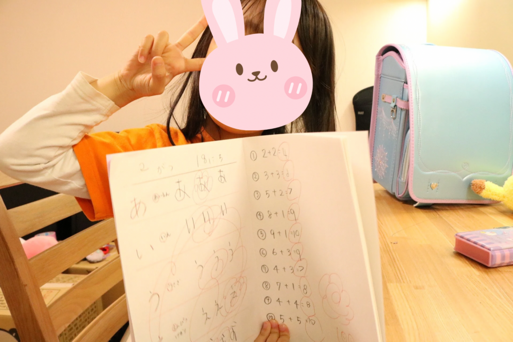 自分のノートを嬉しそうに見せる子ども
